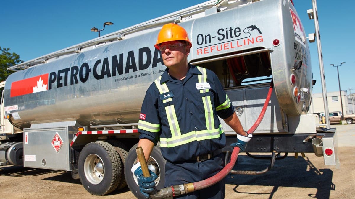 Petro-Canada tanker truck with driver geared up for on-site refuelling